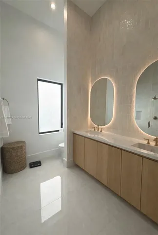 a bathroom with double vanity sink and mirror