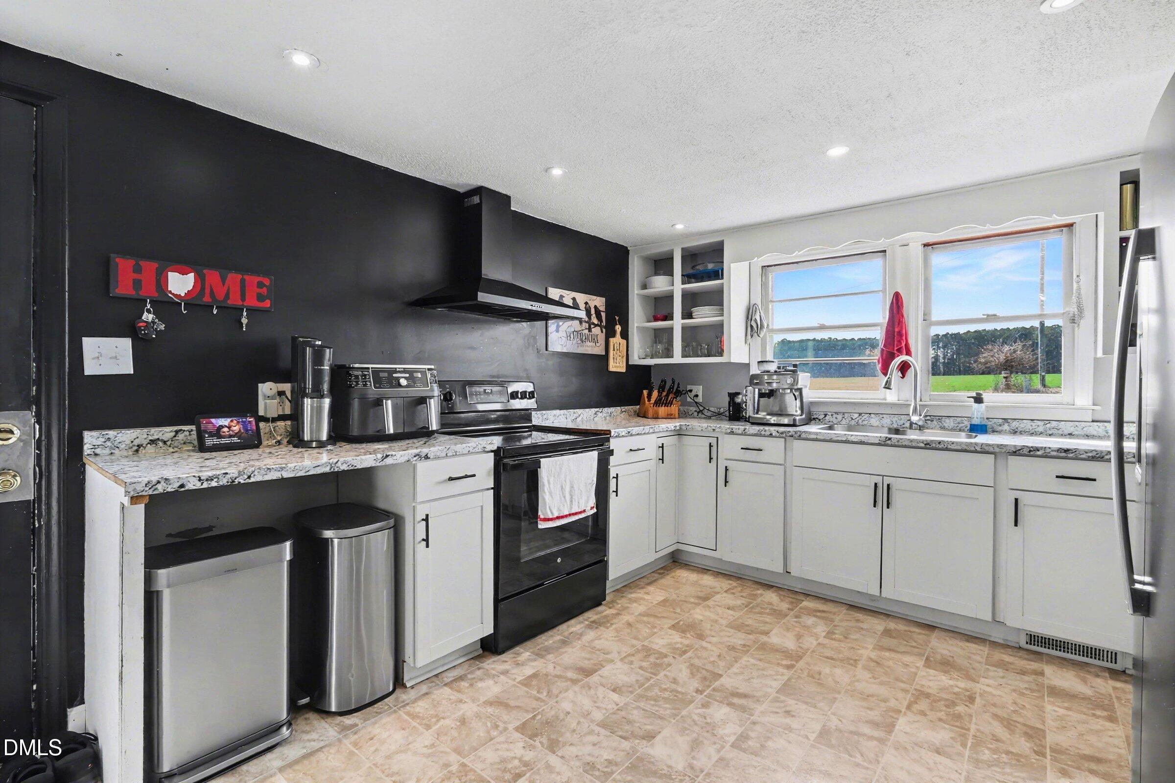 5776 Pearces Road Louisburg, NC 27549 - Photo 10 of 32 a kitchen with sink cabinets and flat screen tv