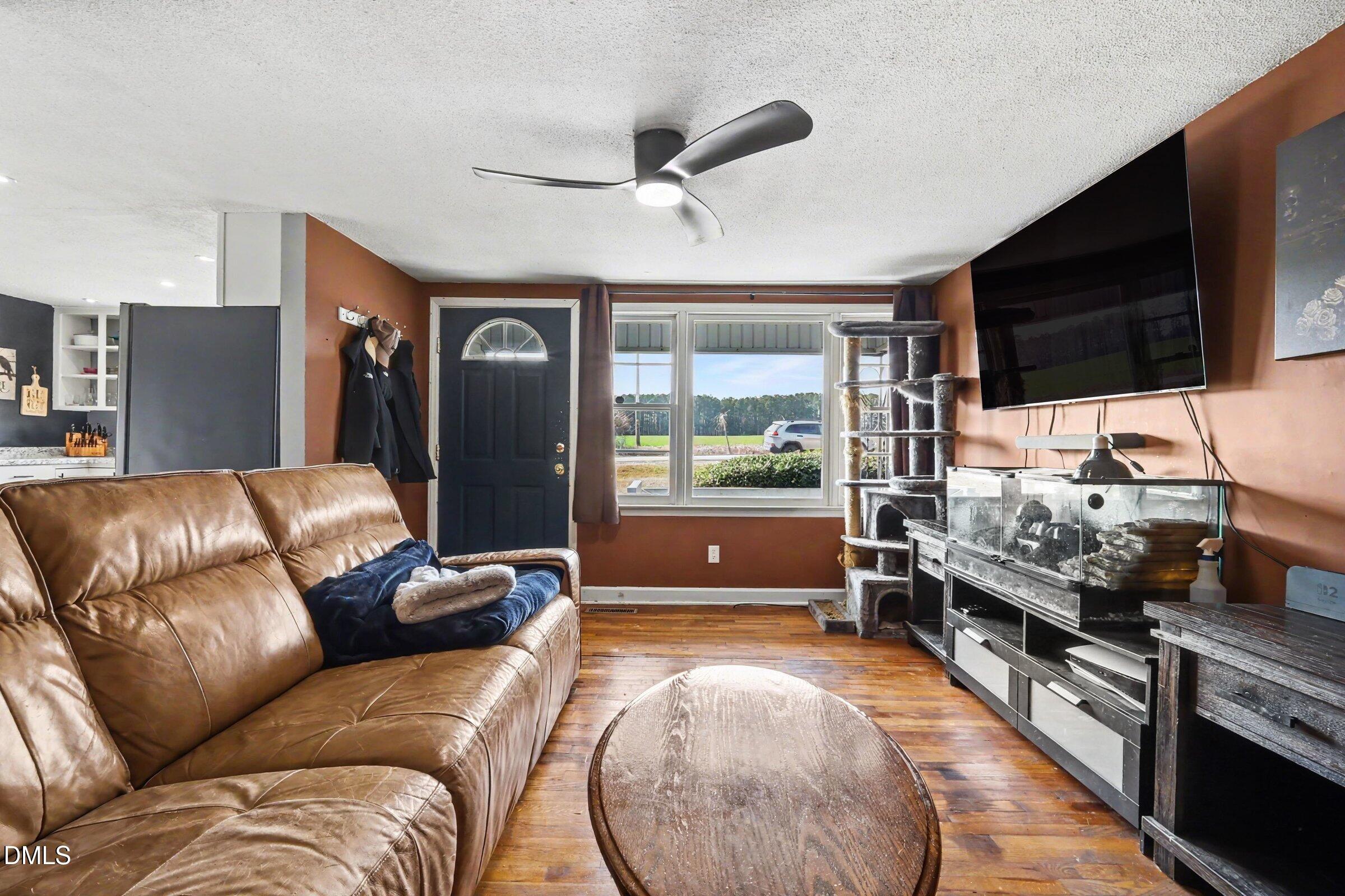 5776 Pearces Road Louisburg, NC 27549 - Photo 22 of 32 a living room with furniture and a flat screen tv