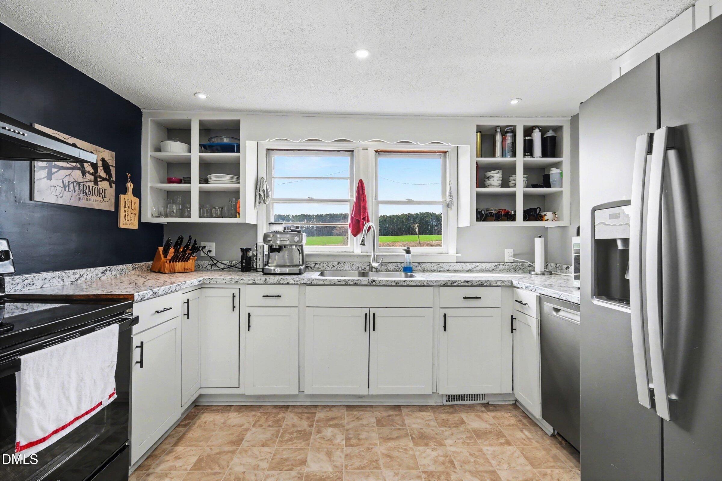 5776 Pearces Road Louisburg, NC 27549 - Photo 8 of 32 a kitchen with stainless steel appliances granite countertop a sink stove and refrigerator