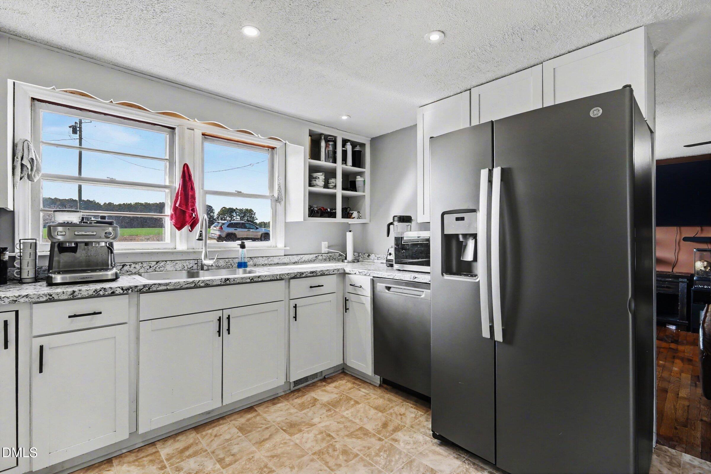 5776 Pearces Road Louisburg, NC 27549 - Photo 9 of 32 a kitchen with stainless steel appliances granite countertop a refrigerator and a sink