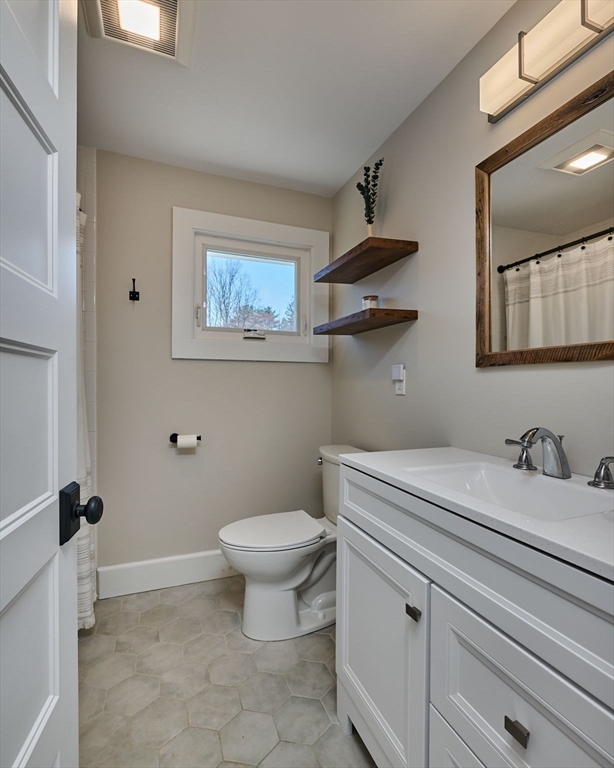69 High Street Southampton, MA 01073 - Photo 26 of 40 a bathroom with a granite countertop sink a toilet and a mirror