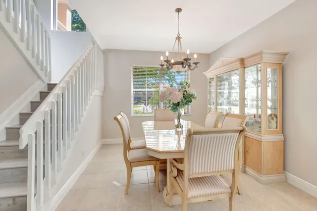 a kitchen with stainless steel appliances granite countertop a refrigerator a stove a sink a dining table and chairs