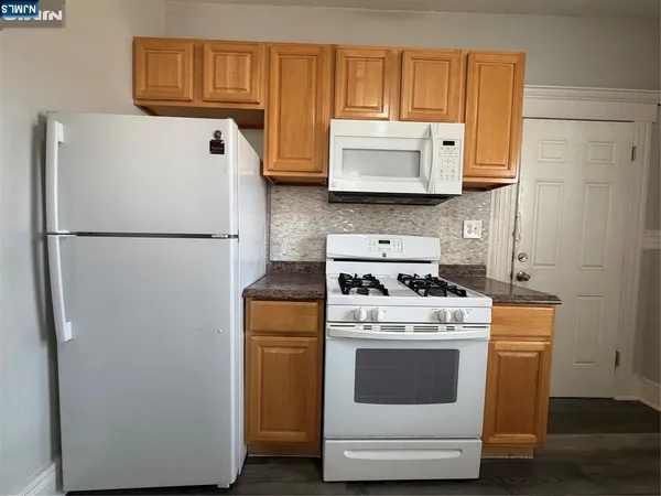 a white refrigerator freezer and a stove sitting inside of a kitchen