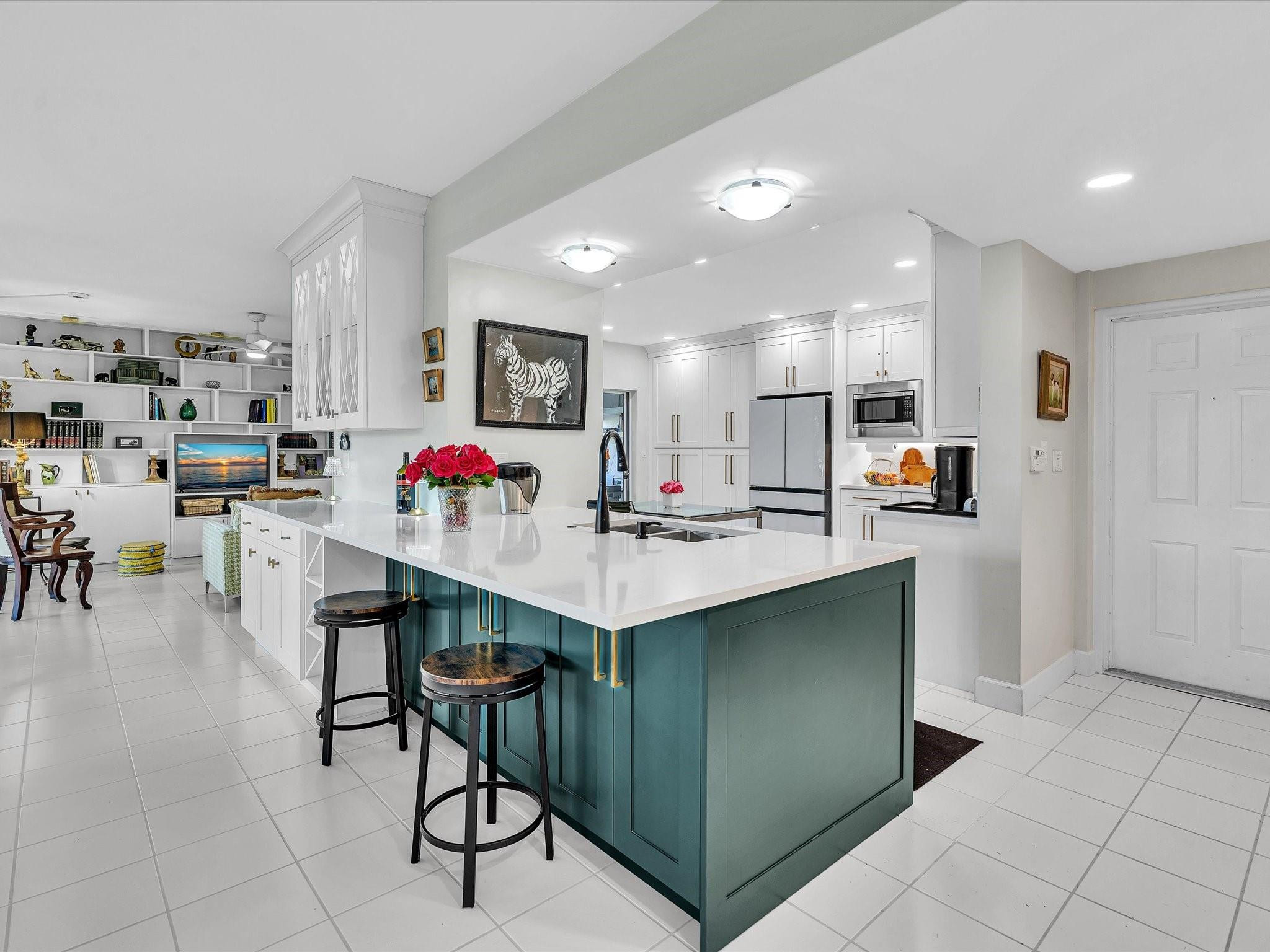 a kitchen with stainless steel appliances kitchen island granite countertop a table chairs and a refrigerator