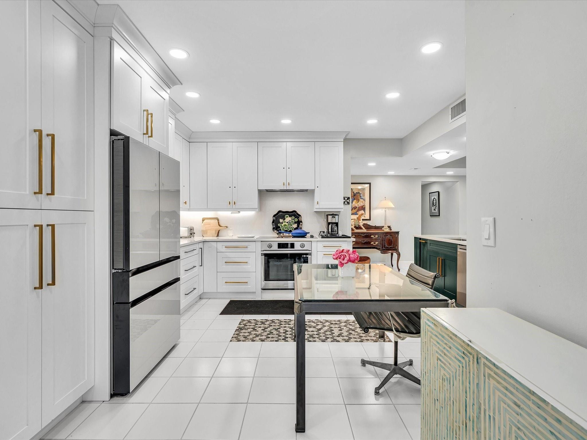 7642 Elm Ridge Drive, Unit 14L Boca Raton, FL 33433 - Photo 13 of 69 a kitchen with stainless steel appliances kitchen island granite countertop a refrigerator oven a sink dishwasher and white cabinets with wooden floor