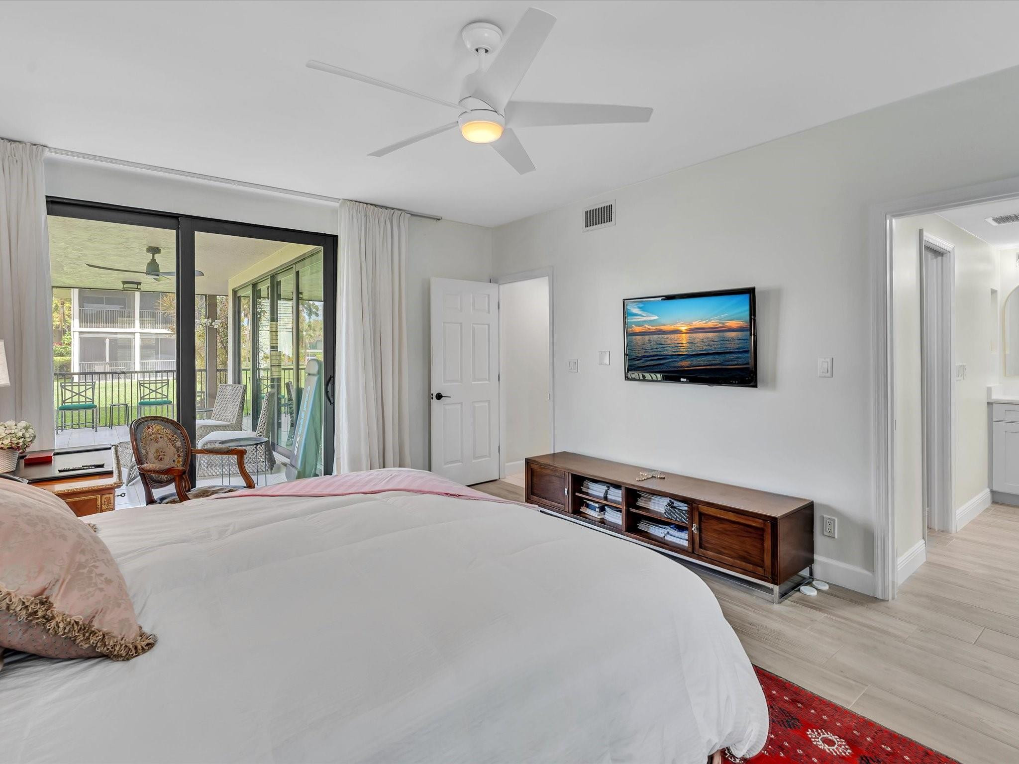 7642 Elm Ridge Drive, Unit 14L Boca Raton, FL 33433 - Photo 48 of 69 a bedroom with a bed a large window and a flat tv screen