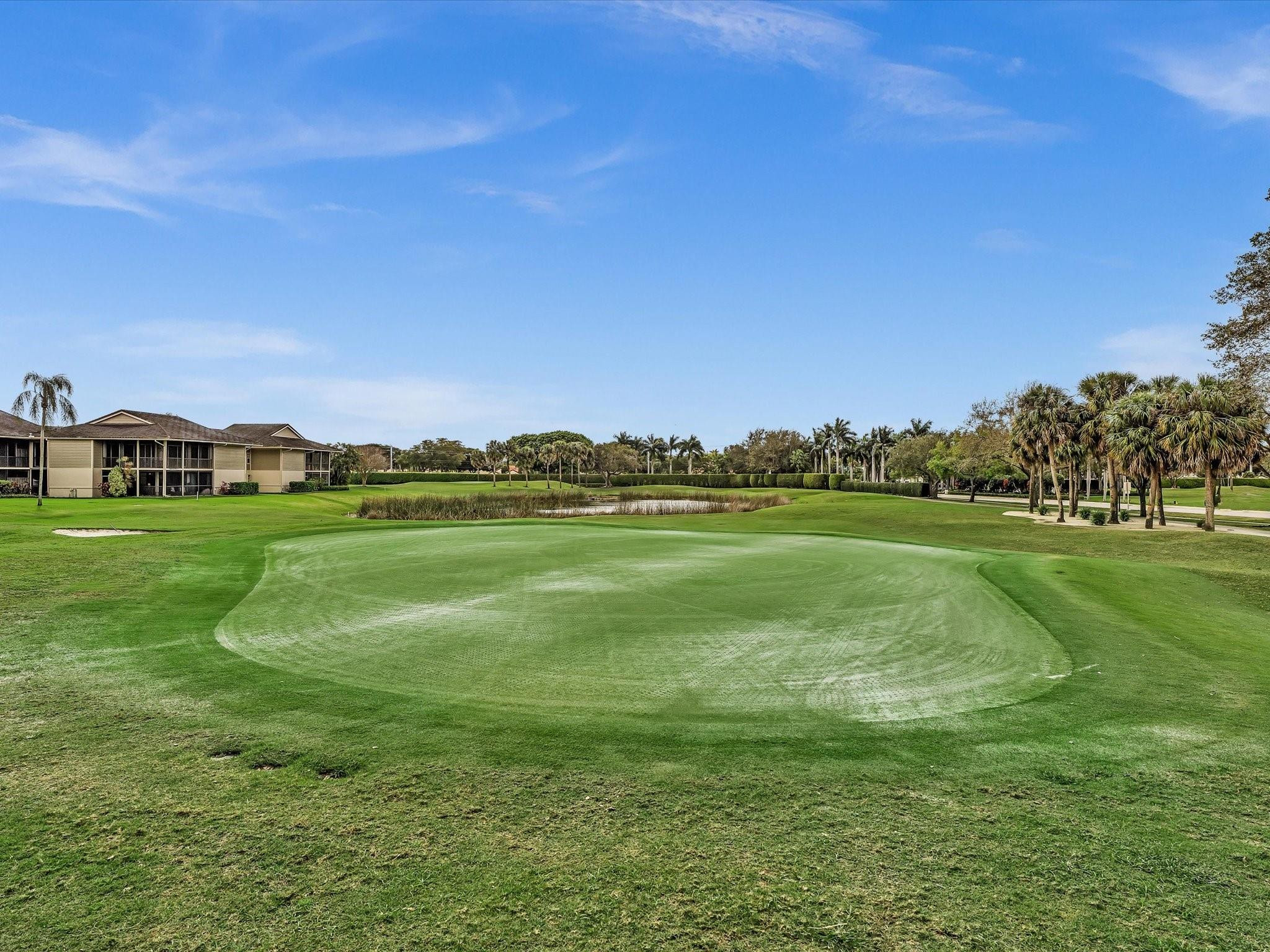 7642 Elm Ridge Drive, Unit 14L Boca Raton, FL 33433 - Photo 61 of 69 a view of a golf course with a lake