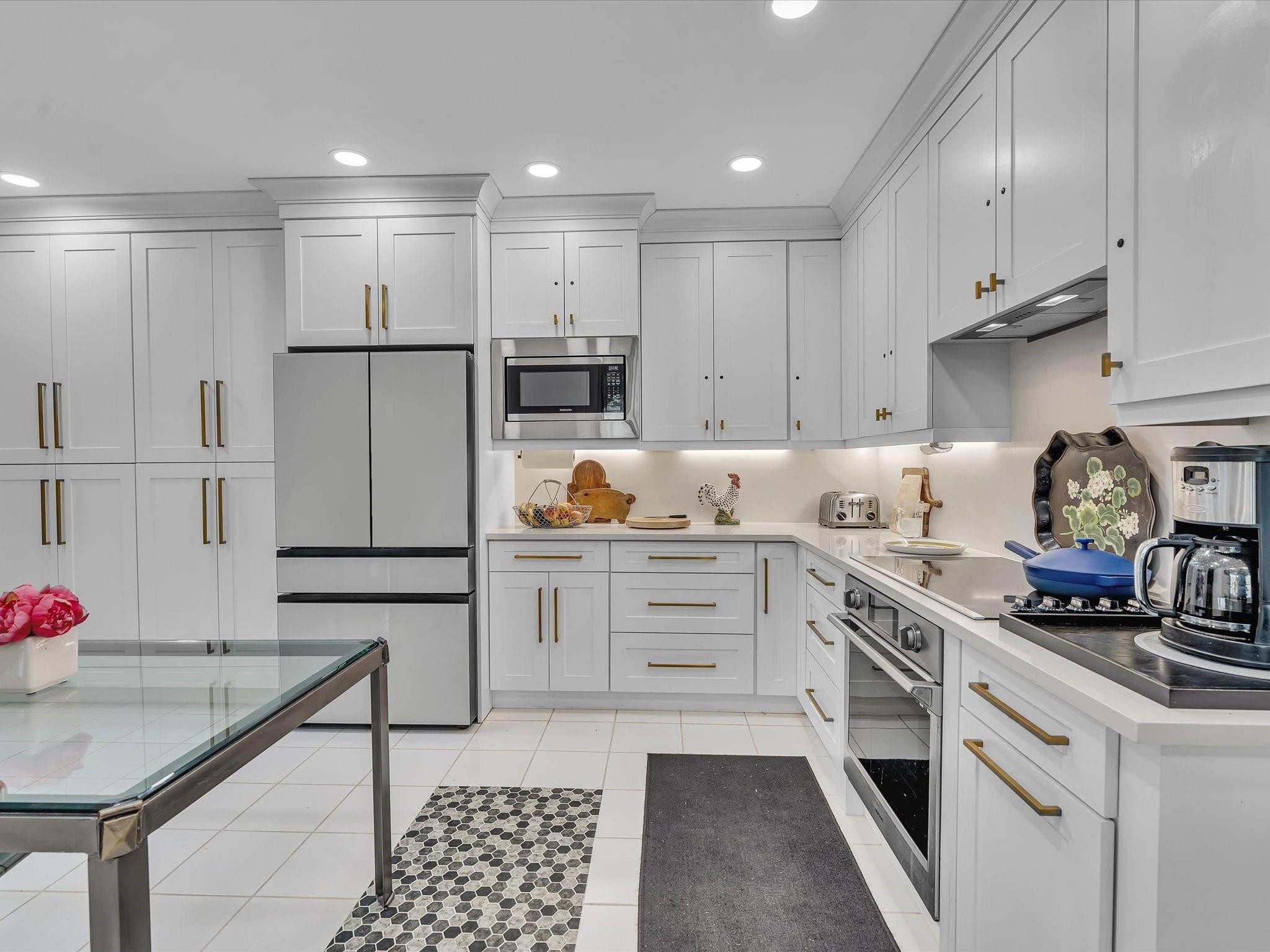 7642 Elm Ridge Drive, Unit 14L Boca Raton, FL 33433 - Photo 10 of 69 a kitchen with granite countertop a sink stove and white cabinets