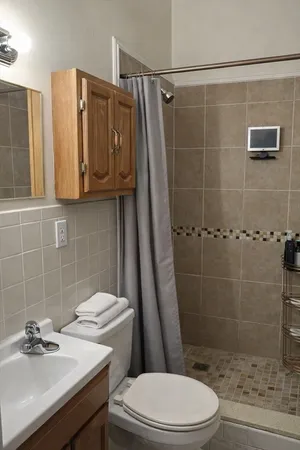 a bathroom with a sink a toilet and shower