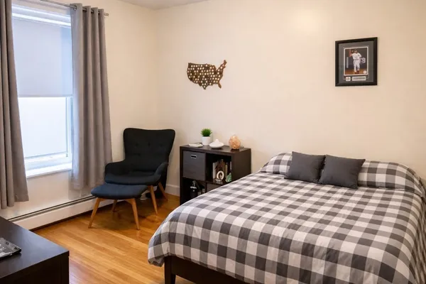 a bedroom with a bed and a chair with rug