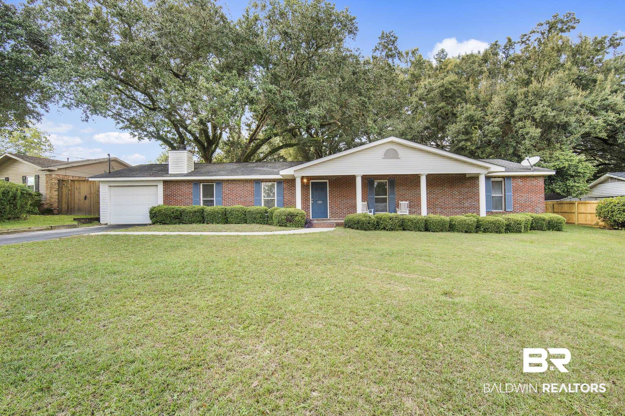 103 Ann Street Daphne, AL 36527 - Photo 1 of 23 Ranch-style home featuring a porch, asphalt driveway, brick siding, an attached garage, and a chimney