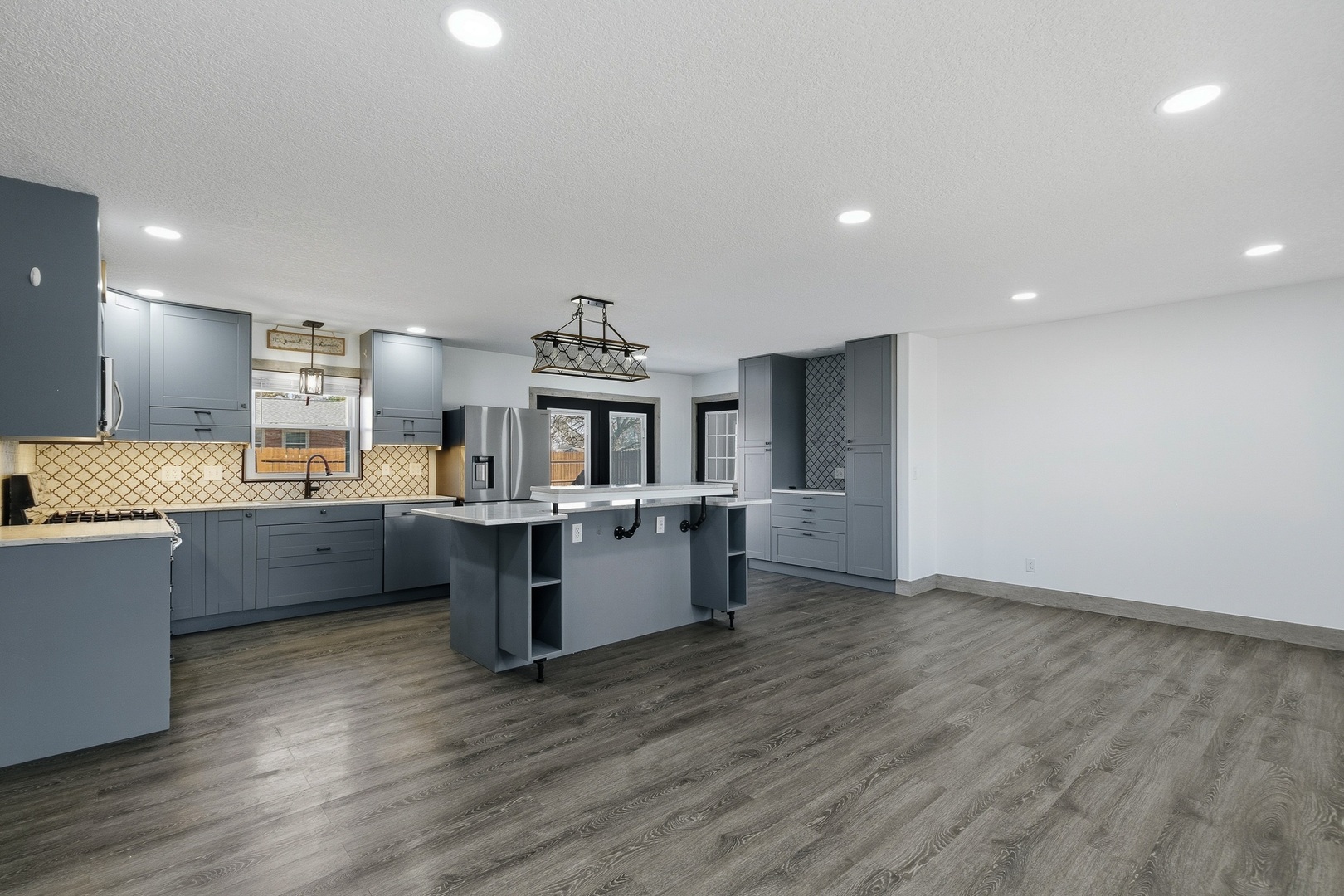 11622 27th Street West Milan, IL 61264 - Photo 11 of 49 a kitchen with stainless steel appliances wooden floors and white cabinets