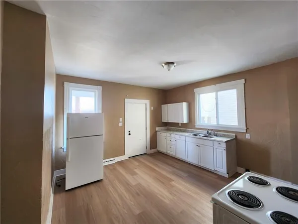 a kitchen with granite countertop a refrigerator stove top oven and sink