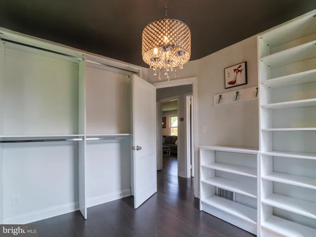 a view of a hallway with wooden floor and a cabinet