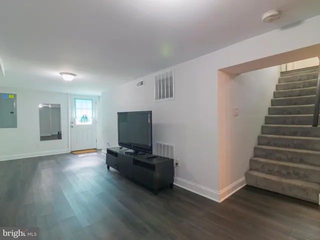 a view of an empty room with wooden floor and windows