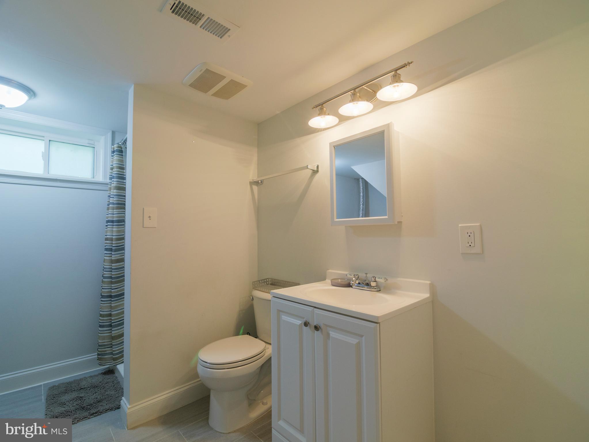 2509 Mason Street Silver Spring, MD 20902 - Photo 22 of 26 a bathroom with a toilet sink vanity and mirror
