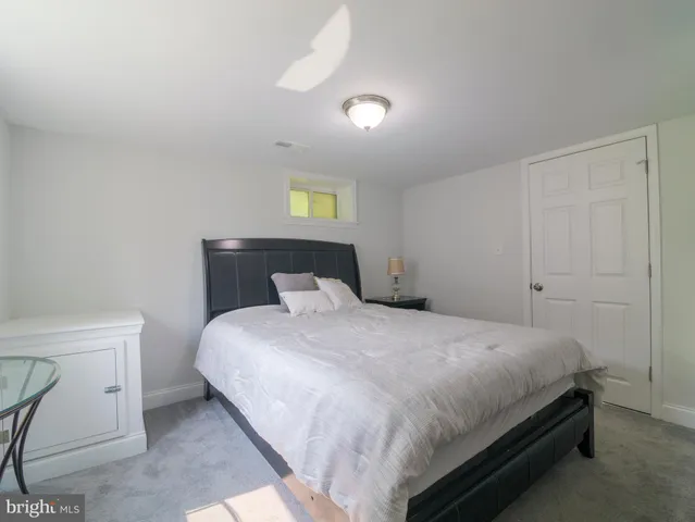 a bedroom with a bed and painting on the wall