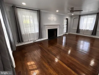 an empty room with wooden floor and a fireplace