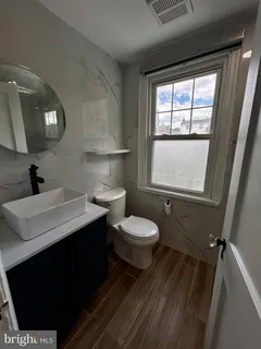 a bathroom with a toilet sink and mirror