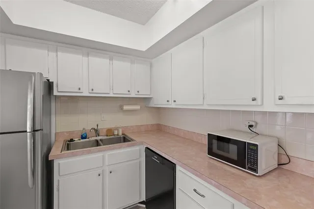 a kitchen with a refrigerator sink and cabinets