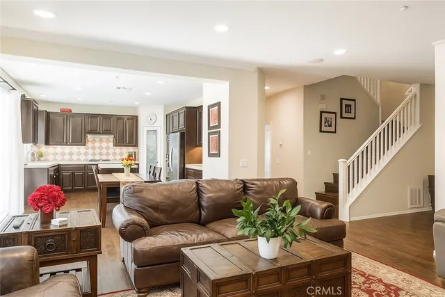 a living room with furniture kitchen view and a window
