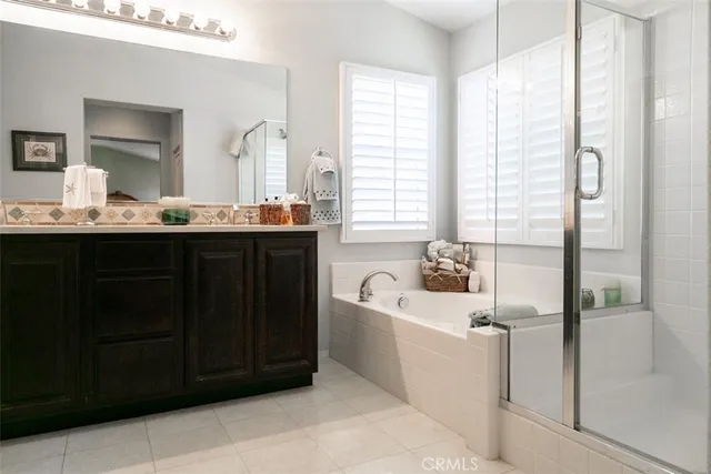 a bathroom with a bathtub a sink a vanity and a large mirror