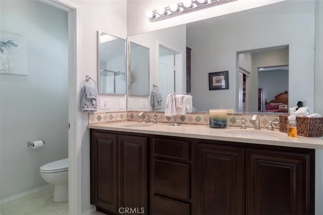a bathroom with a granite countertop sink a toilet and a mirror