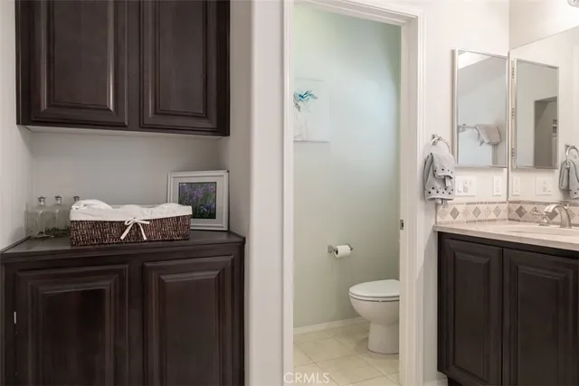 a bathroom with a granite countertop sink a toilet and a mirror