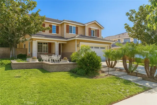 a front view of a house with garden and sitting area