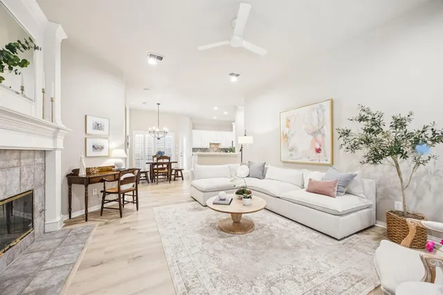a living room with furniture a fireplace and a potted plant