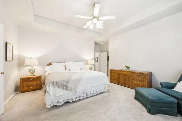 a bedroom with a bed couch dresser and a chandelier