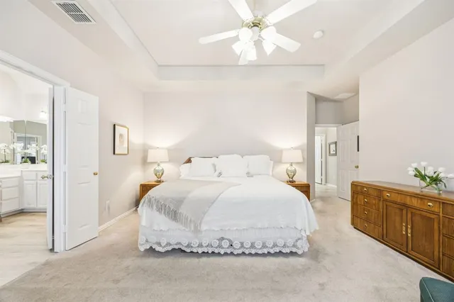 a spacious bedroom with a bed and a chandelier