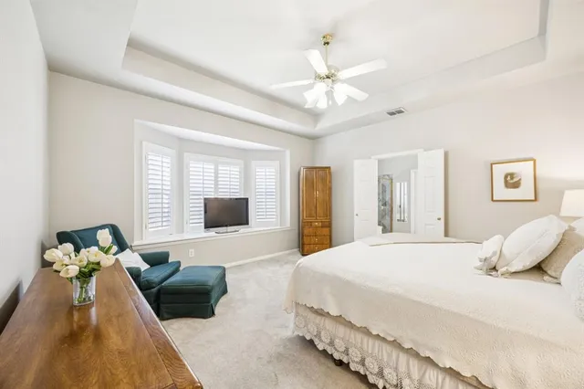 a bedroom with a large bed and a chandelier