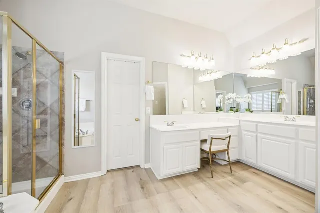a spacious bathroom with a shower a sink and a mirror