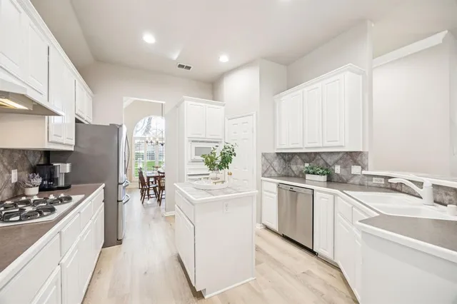 a kitchen with a sink stove and cabinets