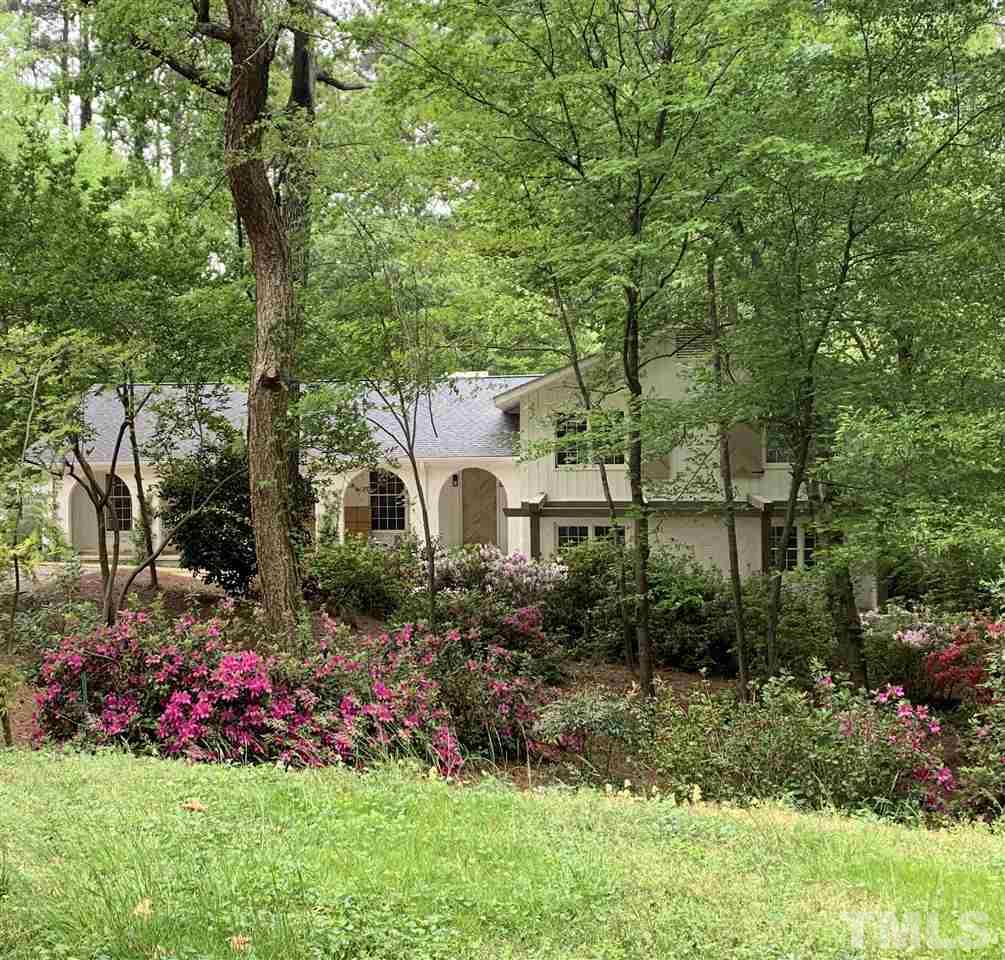 a front view of a house with a yard and potted plants