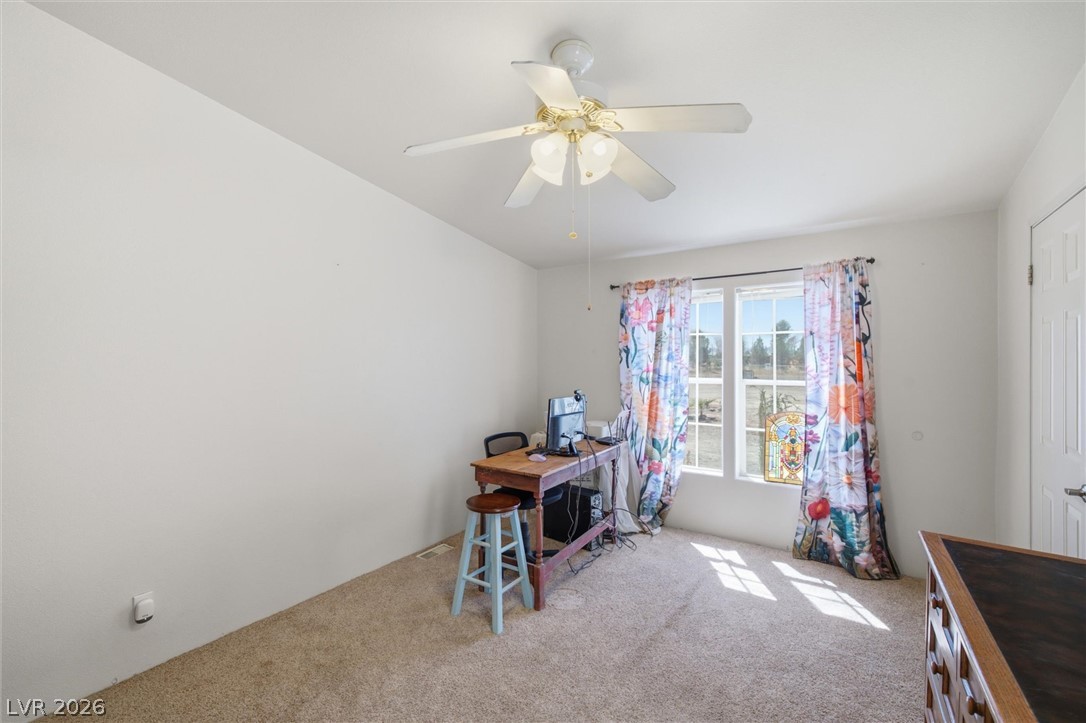 2380 West Simkins Road Pahrump, NV 89060 - Photo 21 of 38 Natural light streams through double windows in a versatile room with soft carpeted flooring.