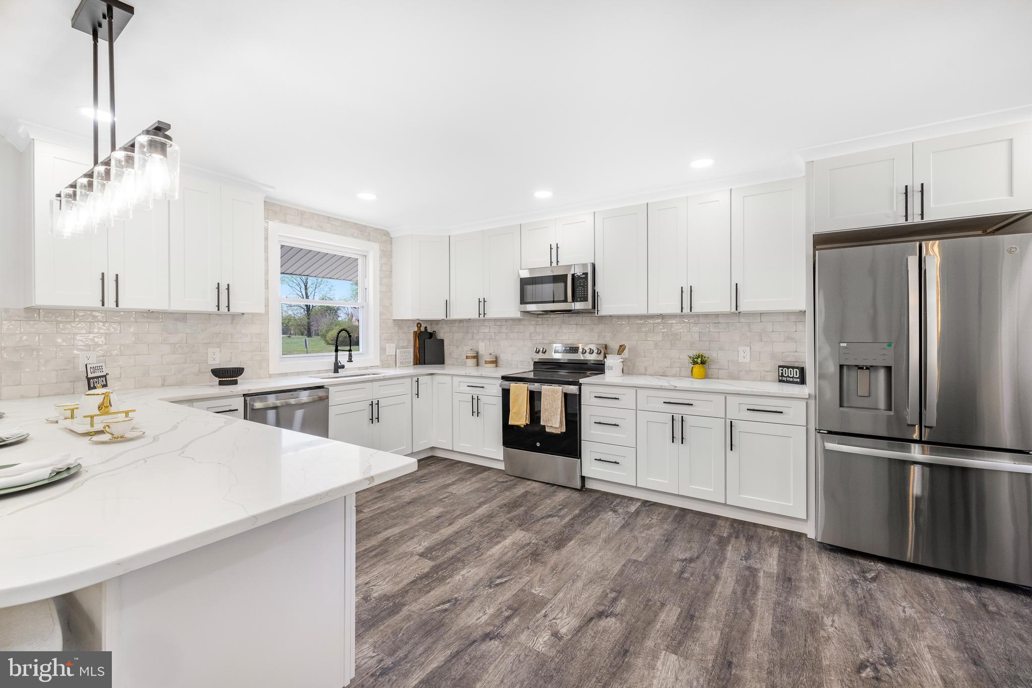 63 Childs Road Elkton, MD 21921 - Photo 7 of 44 a kitchen with a refrigerator stove and white cabinets with wooden floor
