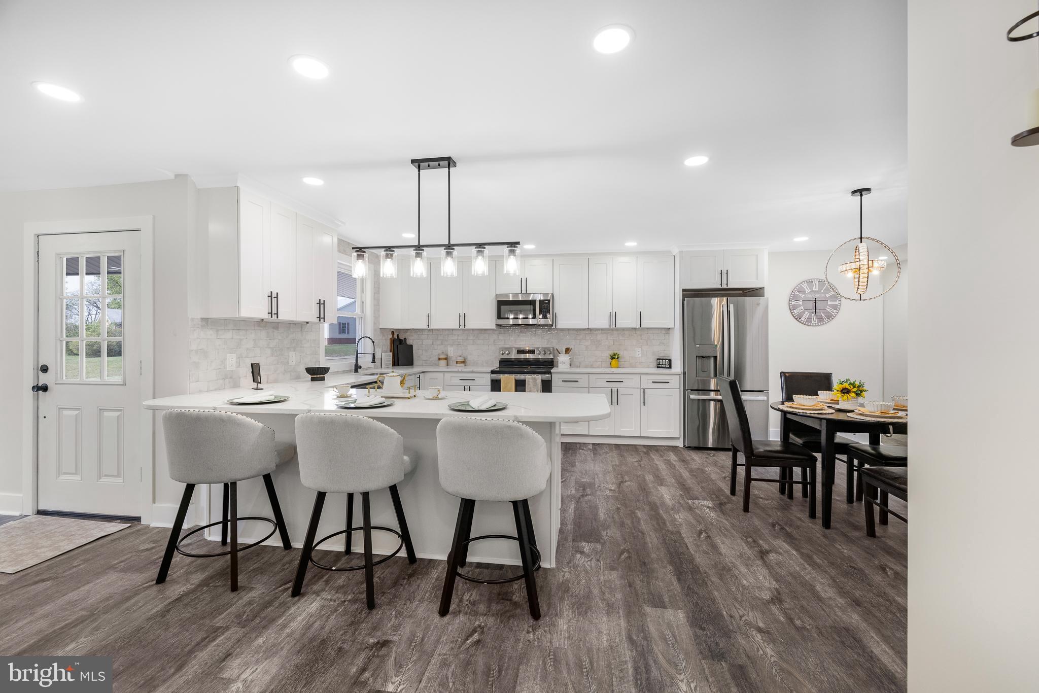 63 Childs Road Elkton, MD 21921 - Photo 10 of 44 a kitchen with stainless steel appliances a dining table chairs stove refrigerator and cabinets