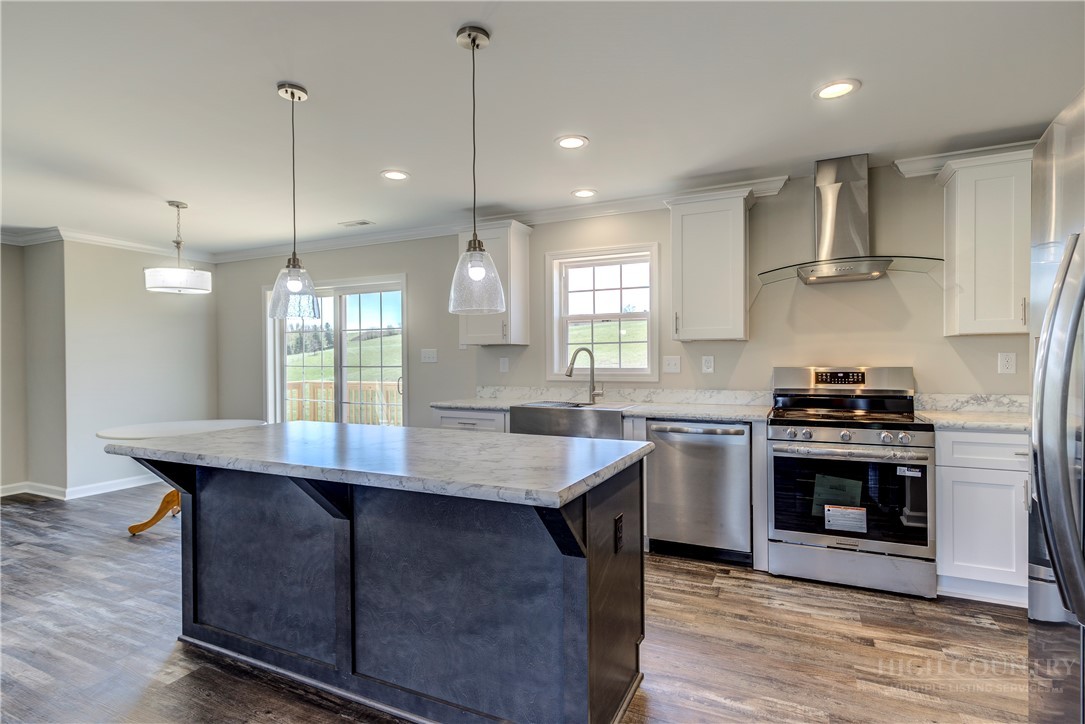 1052 Halsey Knob Road Sparta, NC 28675 - Photo 14 of 28 a kitchen with kitchen island a sink stove and wooden floor