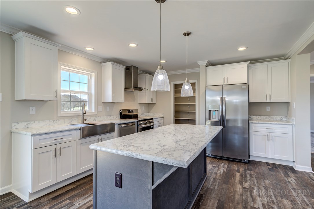 1052 Halsey Knob Road Sparta, NC 28675 - Photo 16 of 28 a kitchen with stainless steel appliances granite countertop a sink a stove a refrigerator and island with wooden floor