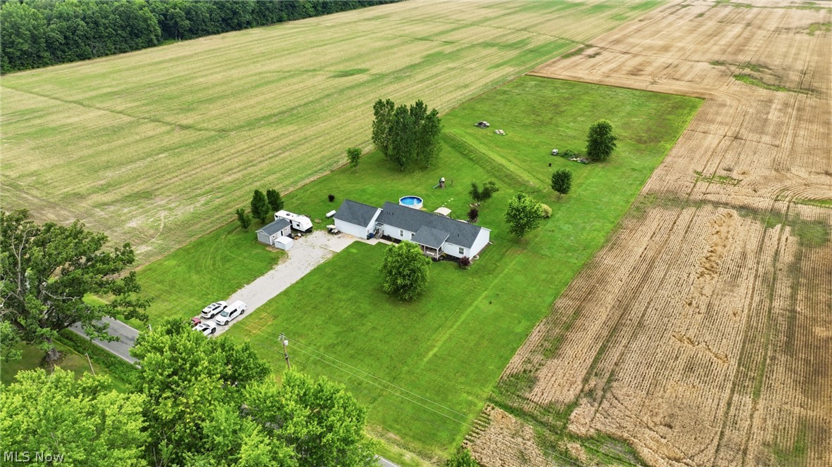 40308 Whitney Road Lagrange, OH 44050 - Photo 2 of 32 Expansive rural property featuring a single-story residence with a white exterior, surrounded by vast open fields