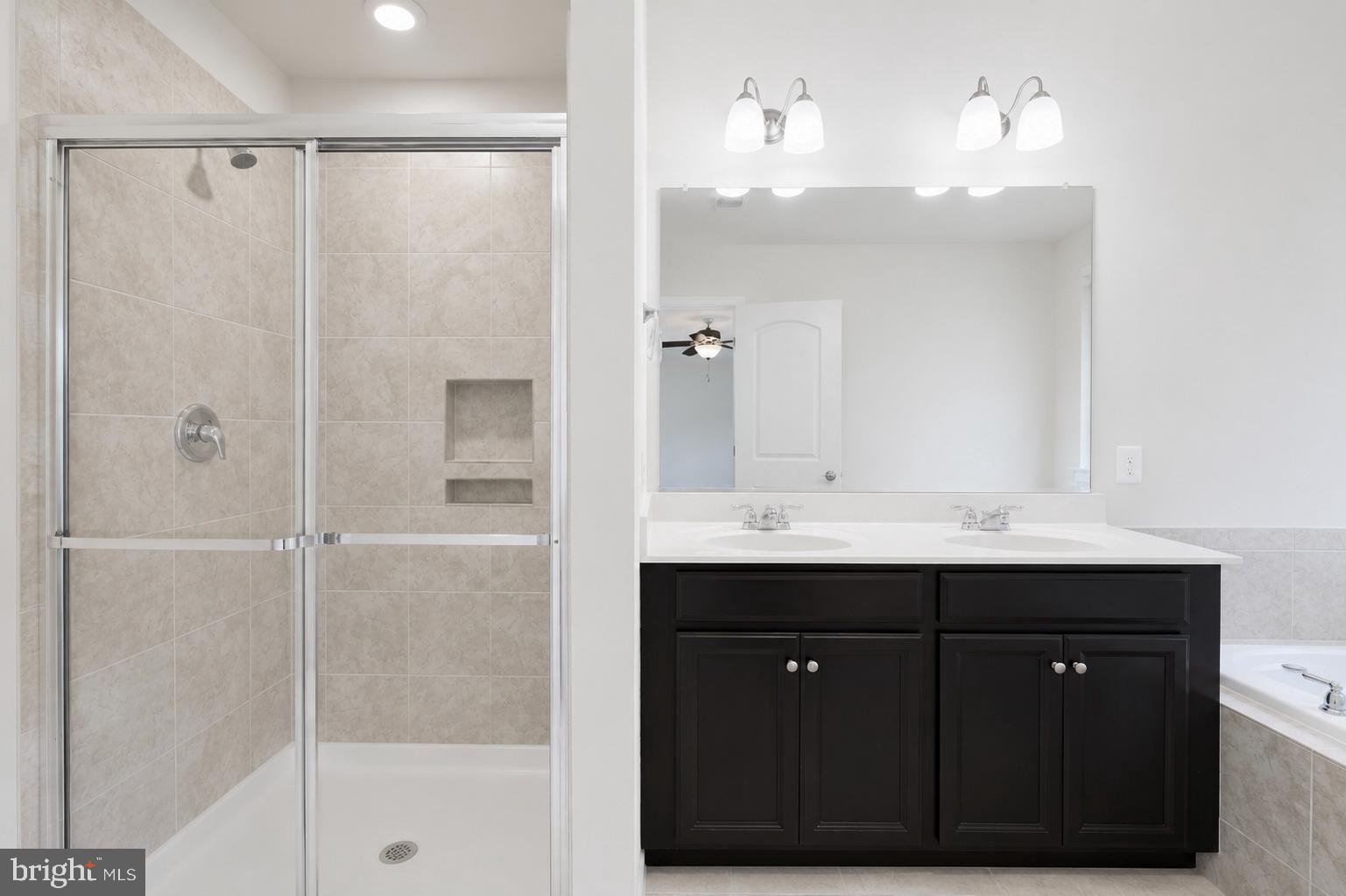 4731 Cambria Road Frederick, MD 21703 - Photo 36 of 63 a bathroom with a shower sink and mirror