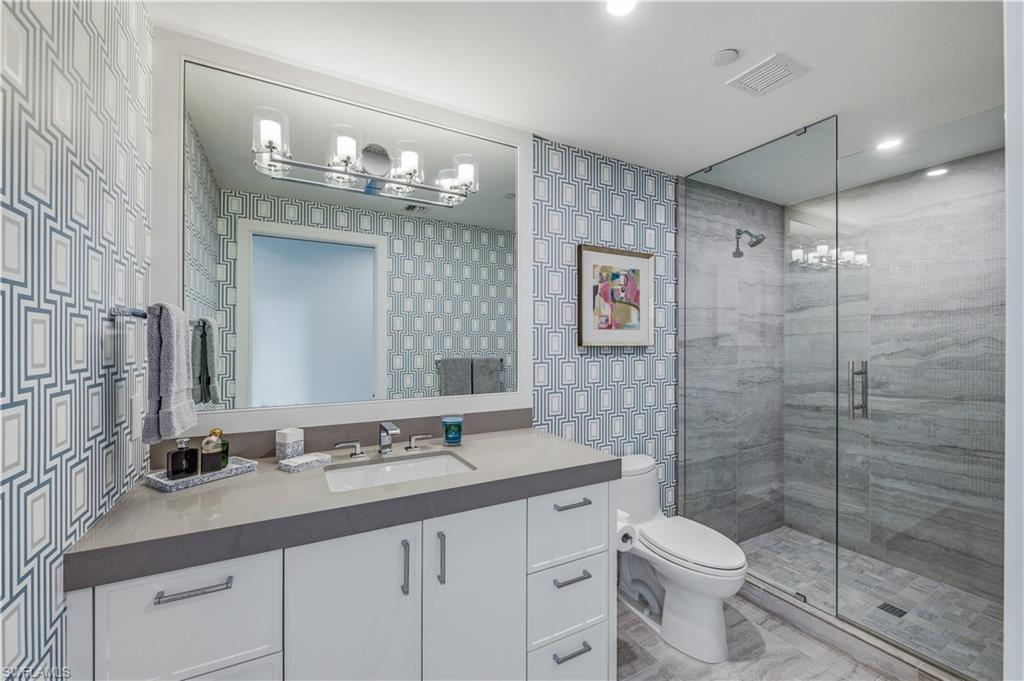 13925 Old Coast Road, Unit 905 Naples, FL 34110 - Photo 15 of 48 a bathroom with a toilet a sink and glass door