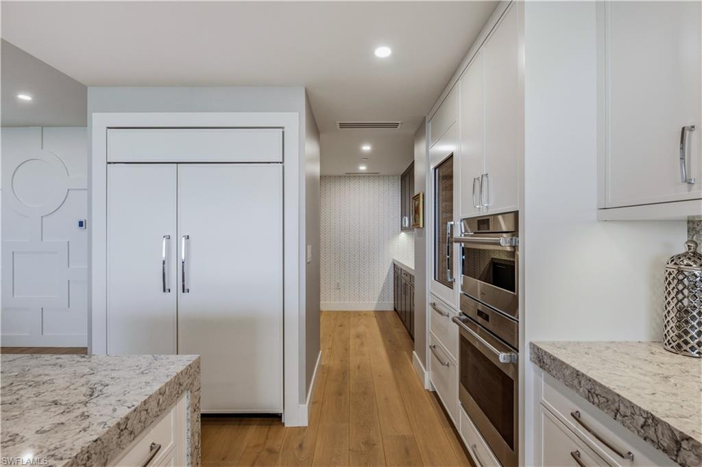 13925 Old Coast Road, Unit 905 Naples, FL 34110 - Photo 7 of 48 a kitchen with stainless steel appliances granite countertop a refrigerator and a sink