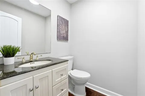 a bathroom with a granite countertop toilet and sink
