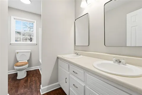 a bathroom with a sink a toilet and a mirror