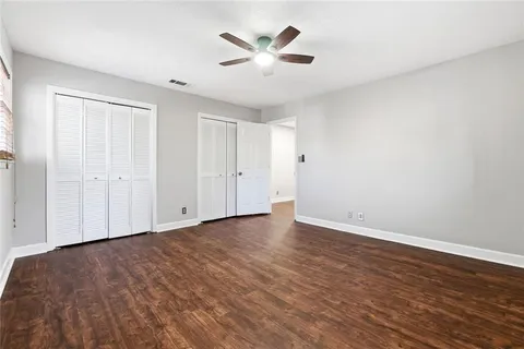 a view of an empty room with window and a ceiling fan