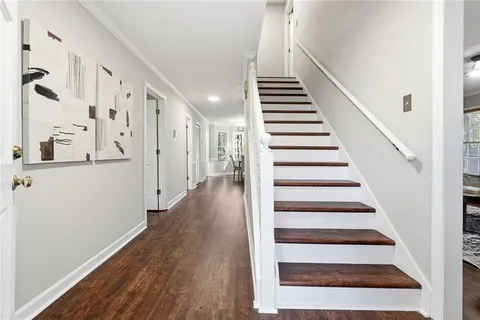 a view of a hallway with wooden floor and entryway